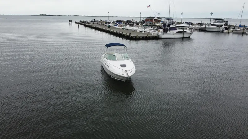 Slide: The Image of 2008 Sea Ray 240 Sundancer boat in a marina, surrounded by other vessels. - 2