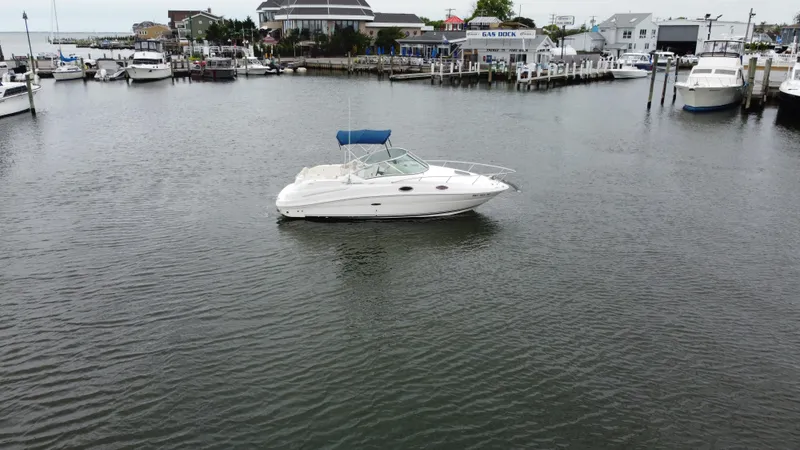 Slide: The Image of 2008 Sea Ray 240 Sundancer boat on calm water near marina. - 3
