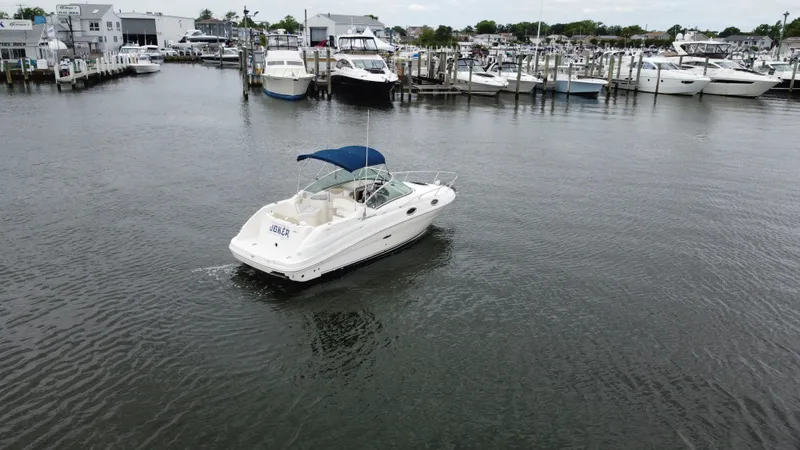 Slide: The Image of 2008 Sea Ray 240 Sundancer boat in a marina, surrounded by other vessels. - 4