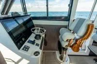 Slide: The Image of Interior of 2023 Invincible 46' Catamaran Pilothouse with modern helm and ocean view. - 7