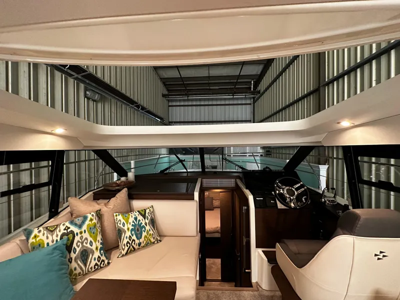 Slide: The Image of Interior of 2020 Prestige 420S yacht with modern seating and helm in a storage facility. - 17