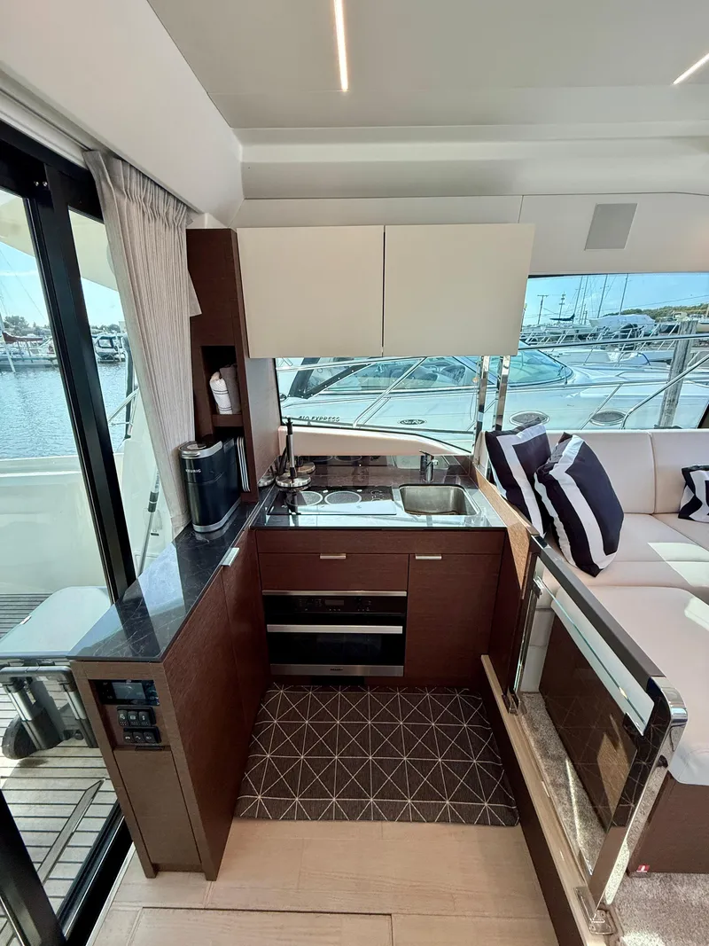 Slide: The Image of Modern kitchen interior on a 2020 Prestige 420S yacht, featuring sleek cabinetry and marina view. - 22