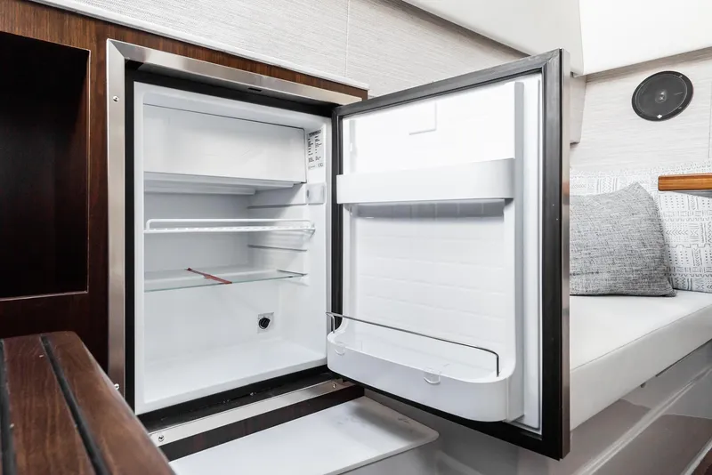 Slide: The Image of Open mini fridge inside 2025 Cruisers Yachts 34 GLS cabin. - 35
