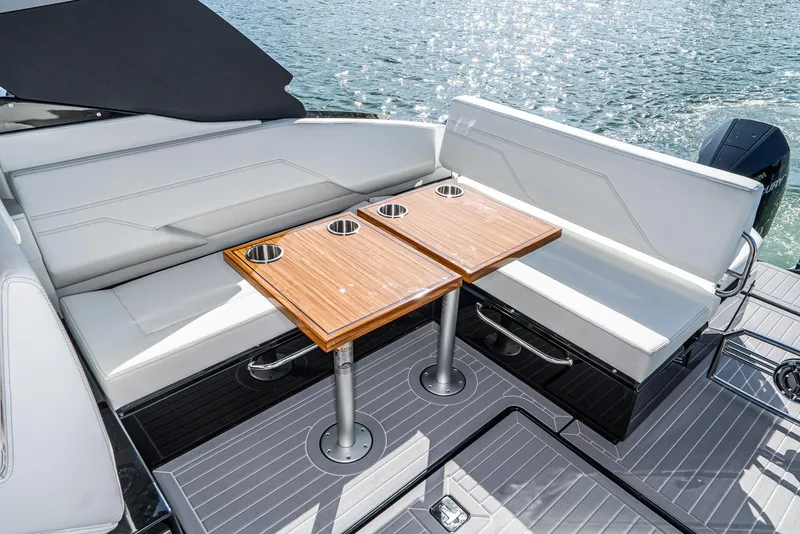 Slide: The Image of Luxury seating area on 2025 Cruisers Yachts 34 GLS, featuring sleek design and wooden table. - 18