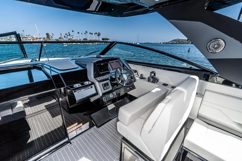 Slide: The Image of 2025 Cruisers Yachts 34 GLS helm with modern controls, overlooking scenic waterfront. - 26