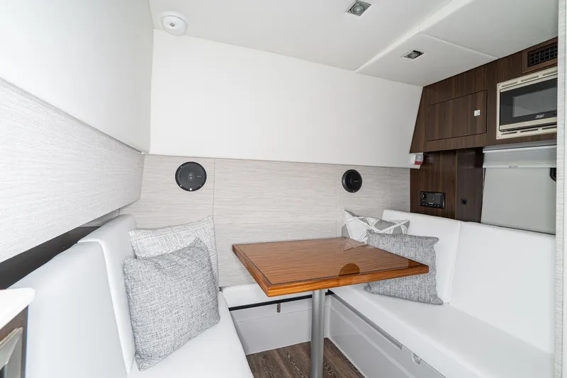 Slide: The Image of 2025 Cruisers Yachts 34 GLS interior with modern seating and wooden table. - 29