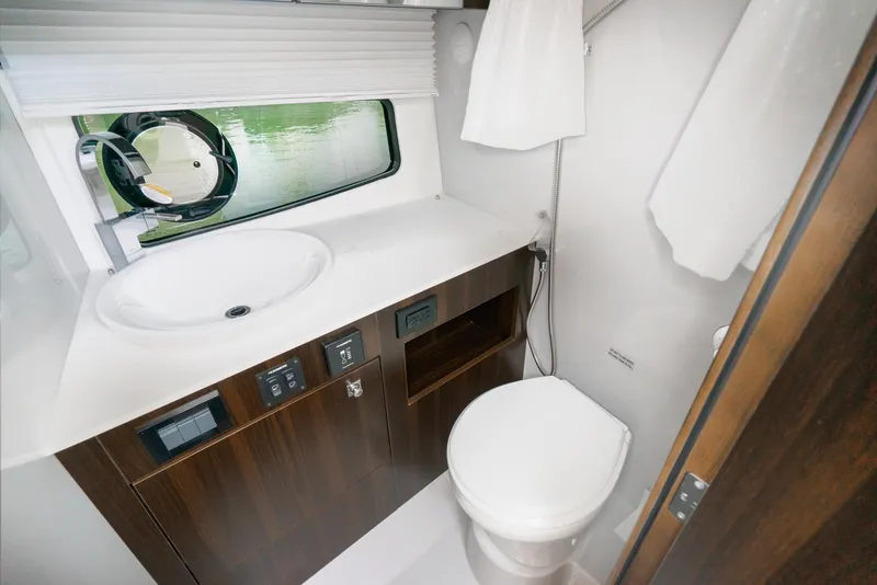 Slide: The Image of Luxurious bathroom in 2025 Cruisers Yachts 34 GLS with modern fixtures and wood cabinetry. - 37