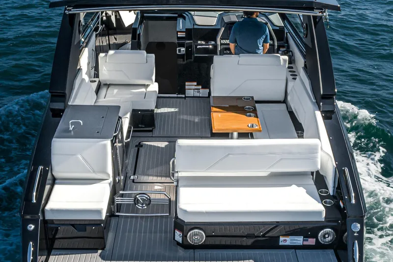 Slide: The Image of 2025 Cruisers Yachts 34 GLS interior with white seating and wooden table on open water. - 39