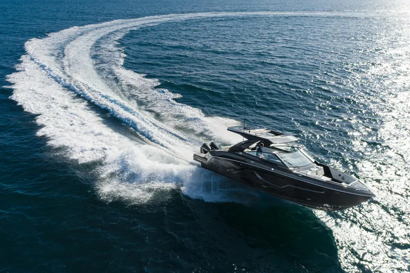 Slide: The Image of 2025 Cruisers Yachts 34 GLS speeding on open water, creating a dynamic wake. - 4