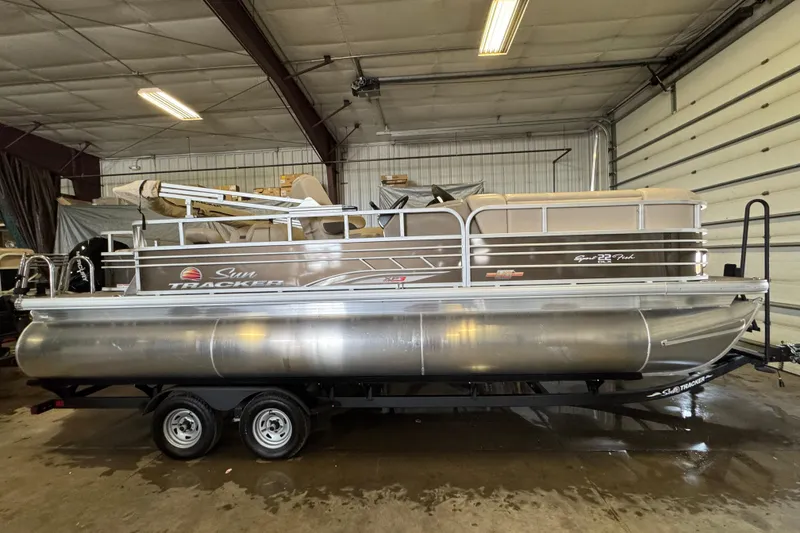 Slide: The Image of 2023 Sun Tracker SportFish 22 XP3 pontoon boat in indoor storage. - 3