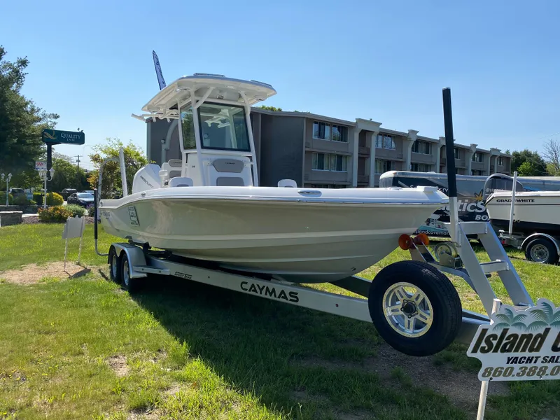 Slide: The Image of 2023 Caymas 26 HB boat on trailer, displayed outdoors. - 13