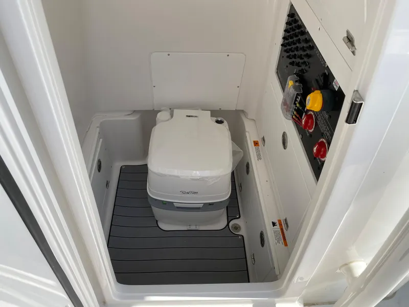 Slide: The Image of 2023 Caymas 26 HB boat interior with portable toilet and control panel. - 3