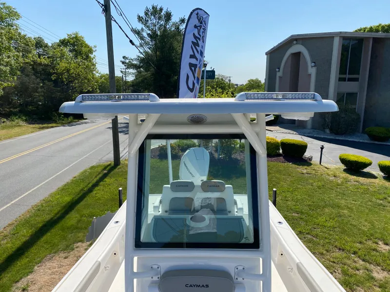 Slide: The Image of 2023 Caymas 26 HB boat with T-top and windshield, parked outdoors. - 8