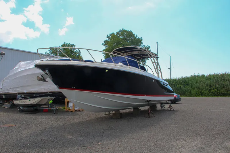 Slide: The Image of 2017 Chris-Craft Launch 36 boat on dry dock, black hull with red stripe. - 14
