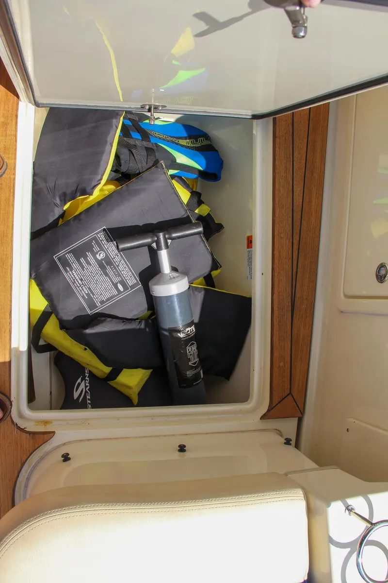 Slide: The Image of Storage compartment on a 2017 Chris-Craft Launch 36 boat with life jackets and a pump. - 34