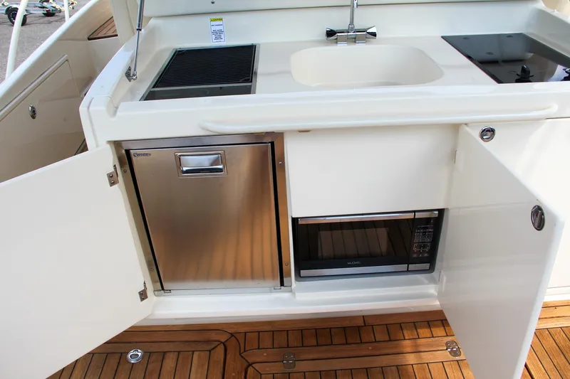 Slide: The Image of 2017 Chris-Craft Launch 36 boat galley with sink, grill, fridge, and microwave. - 47