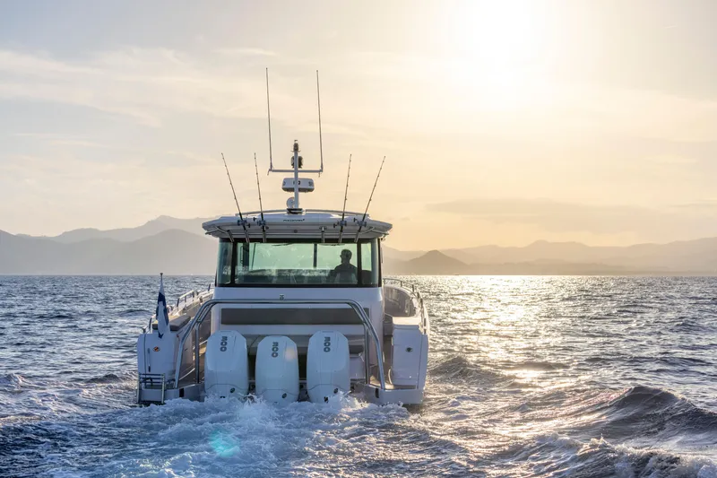 Slide: The Image of 2024 Axopar 45 boat cruising at sunset on open water. - 2