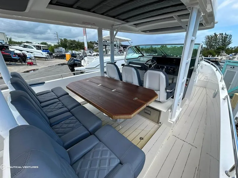 Slide: The Image of 2018 Axopar 37 Sun Top boat interior with seating and table. - 17