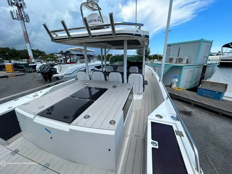Slide: The Image of 2018 Axopar 37 Sun Top boat docked at marina, featuring spacious deck and seating area. - 19