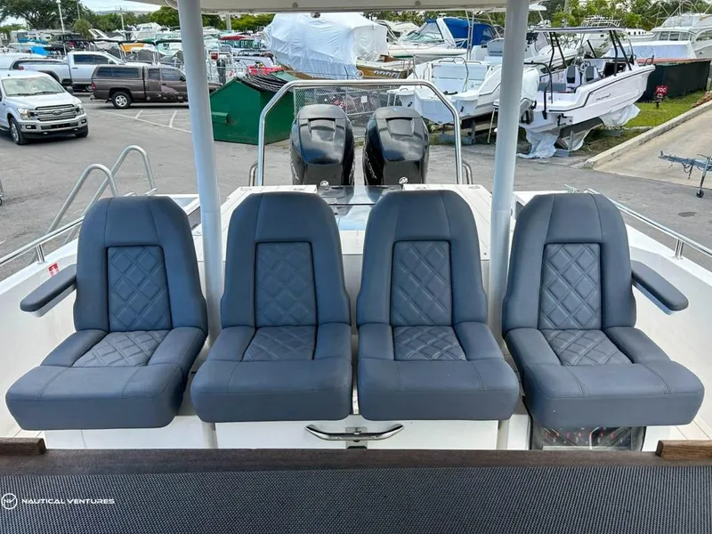 Slide: The Image of 2018 Axopar 37 Sun Top boat with four grey seats in marina. - 20