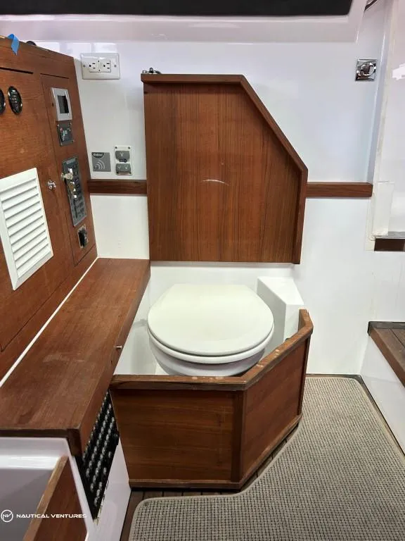 Slide: The Image of 2018 Axopar 37 Sun Top interior with wooden cabinetry and marine toilet. - 22