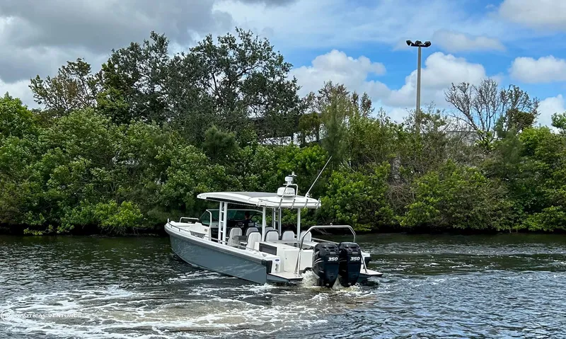 Slide: The Image of 2018 Axopar 37 Sun Top boat cruising on a river with lush greenery in the background. - 4