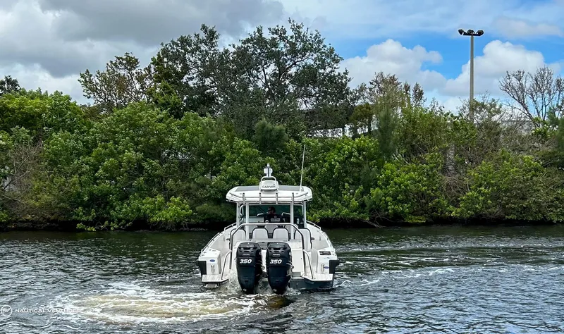 Slide: The Image of 2018 Axopar 37 Sun Top boat cruising on a river with lush greenery in the background. - 5
