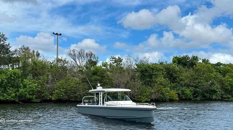 Slide: The Image of 2018 Axopar 37 Sun Top boat cruising on a river with lush greenery in the background. - 7