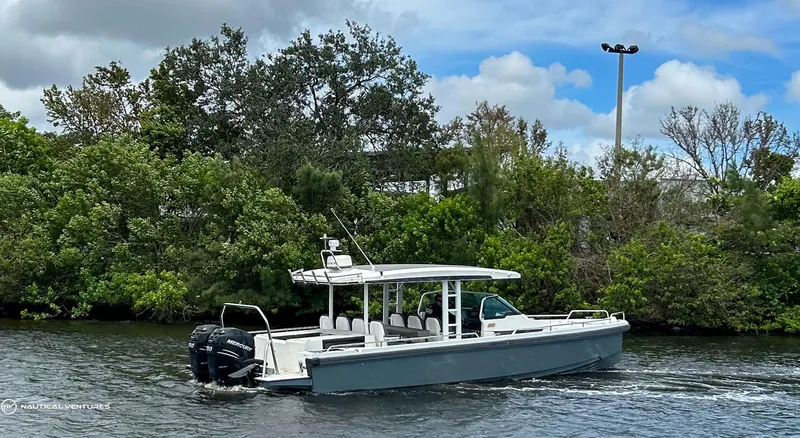 Slide: The Image of 2018 Axopar 37 Sun Top boat cruising on a river with lush greenery in the background. - 8
