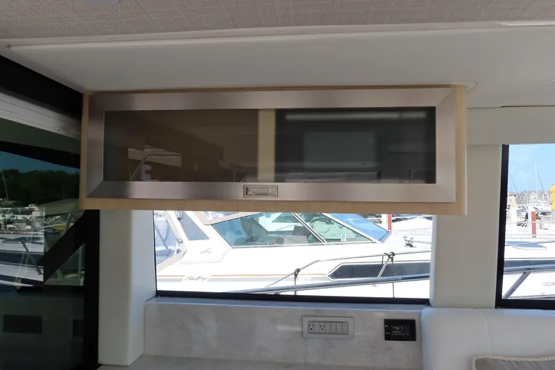 Slide: The Image of 2024 Regal 38 Fly yacht interior with sleek overhead cabinet and marina view. - 12