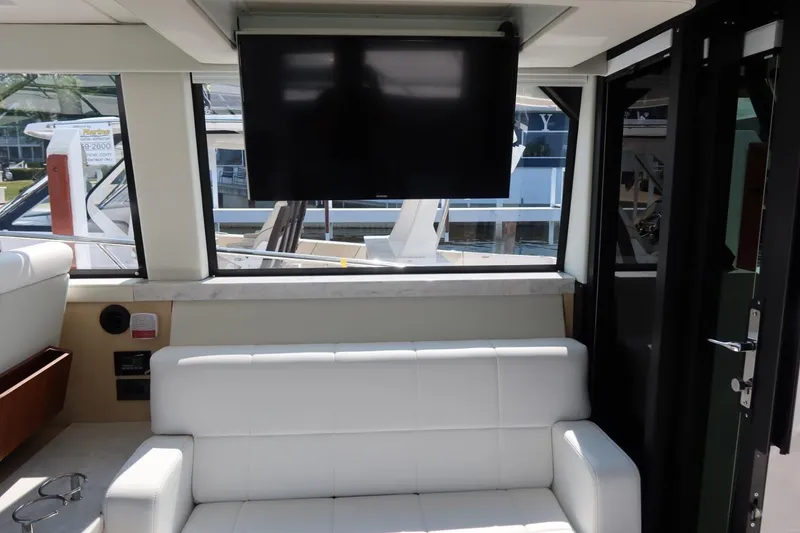Slide: The Image of Interior of 2024 Regal 38 Fly yacht with white sofa and mounted TV. - 13