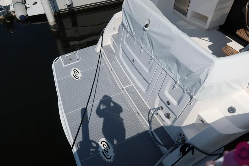 Slide: The Image of 2024 Regal 38 Fly yacht stern with covered seating and deck details. - 2
