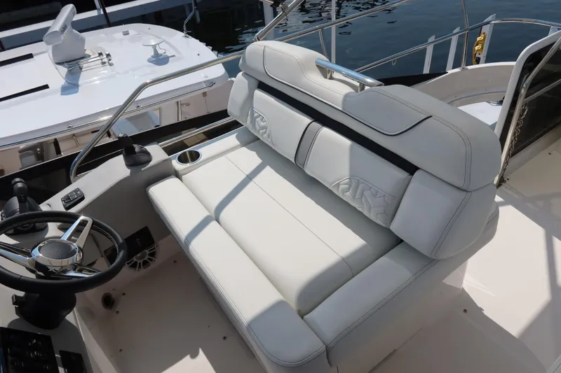 Slide: The Image of 2024 Regal 38 Fly yacht with luxurious white seating and steering wheel. - 22