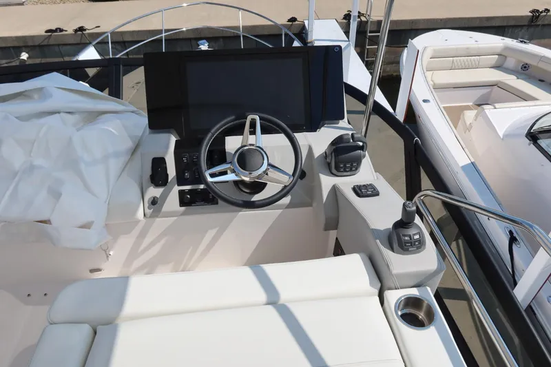 Slide: The Image of 2024 Regal 38 Fly yacht helm with modern controls and steering wheel. - 23