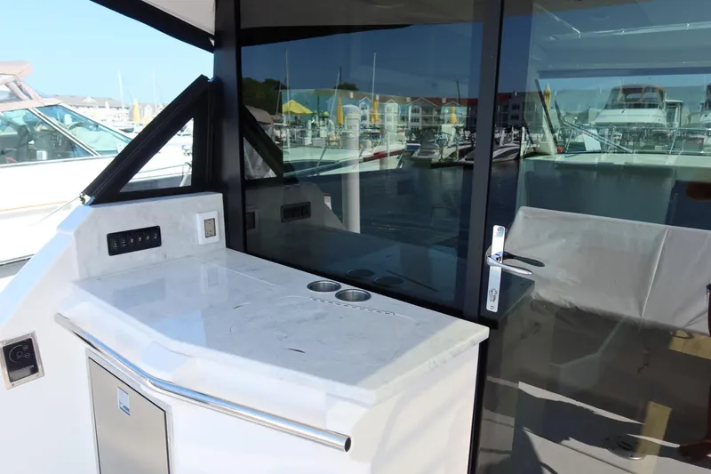 Slide: The Image of 2024 Regal 38 Fly yacht with sleek outdoor kitchenette and marina view. - 4