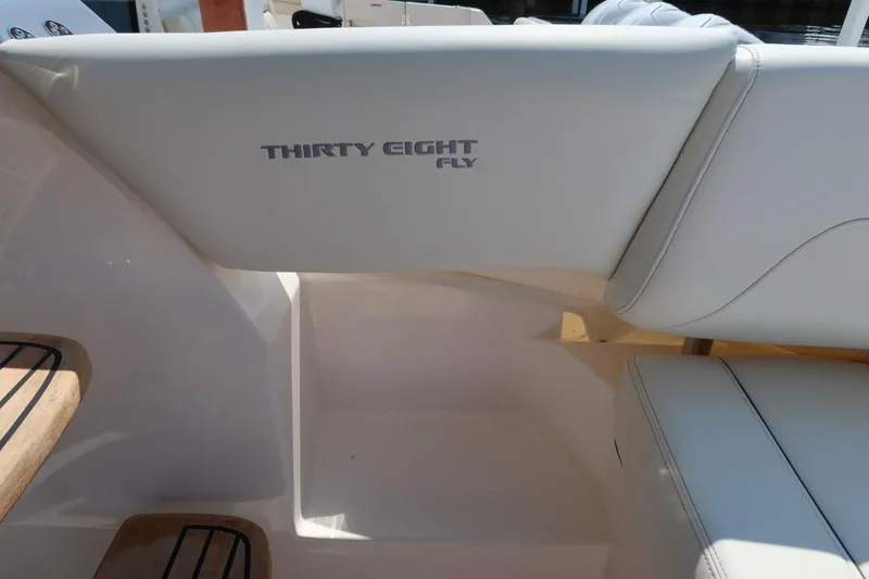 Slide: The Image of 2024 Regal 38 Fly yacht interior seating with "Thirty Eight Fly" branding. - 9