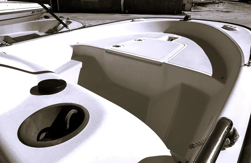 Slide: The Image of 2002 Boston Whaler 130 Sport boat interior, featuring storage compartments and seating area. - 5