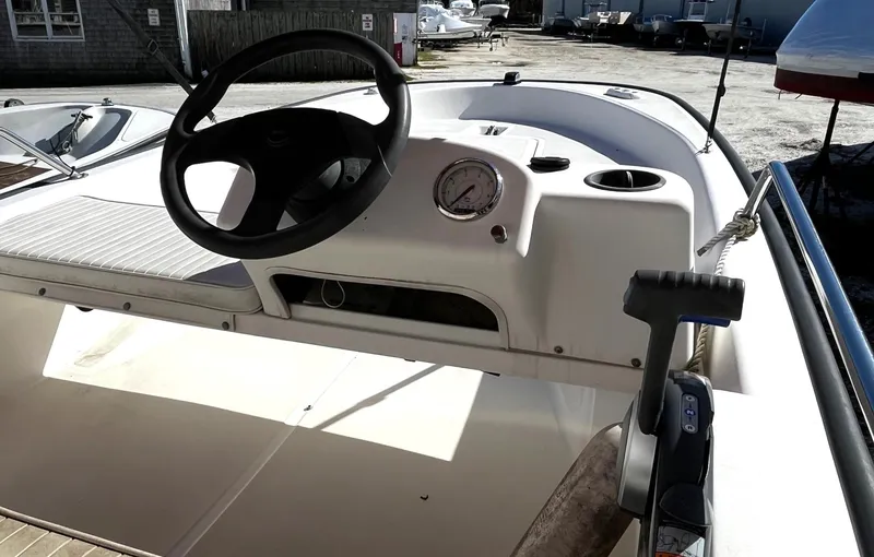 Slide: The Image of 2002 Boston Whaler 130 Sport boat dashboard with steering wheel and controls. - 6