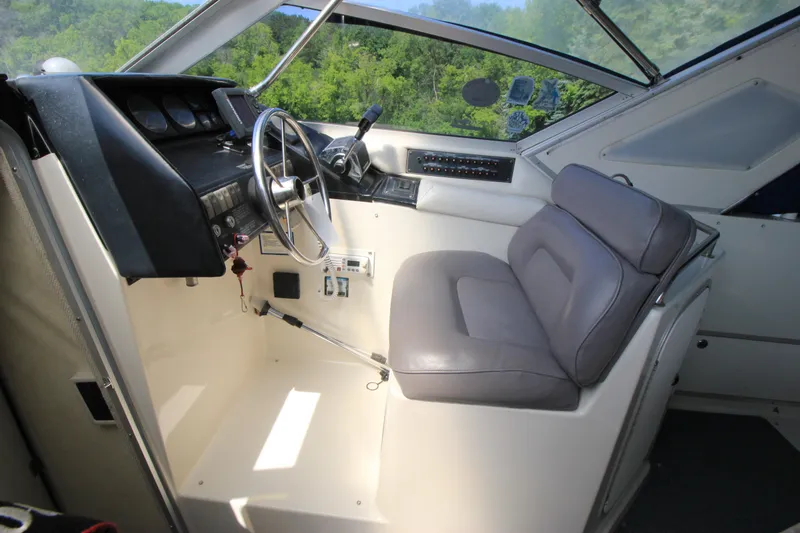 Slide: The Image of 1994 Bayliner 3055 Sunbridge helm station with steering wheel and captain's seat. - 10