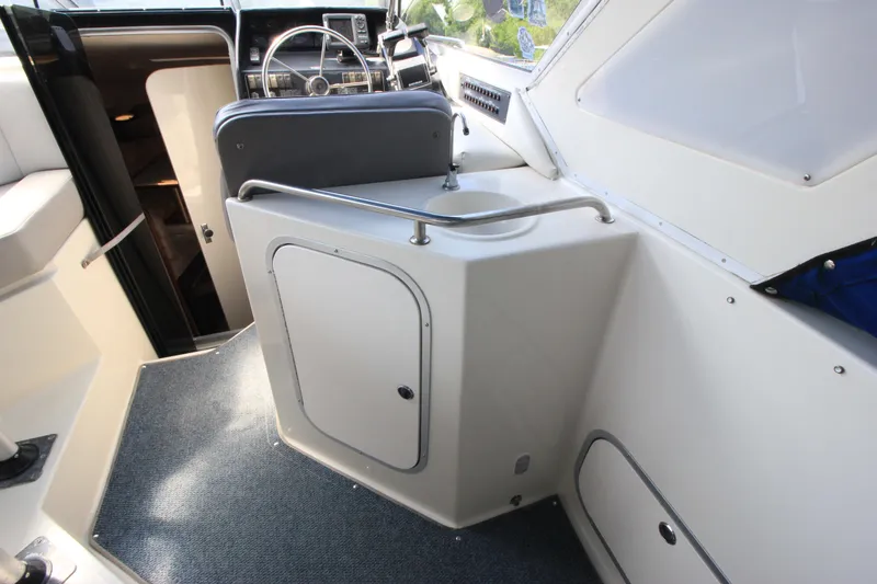 Slide: The Image of 1994 Bayliner 3055 Sunbridge cockpit with helm and storage compartments. - 13