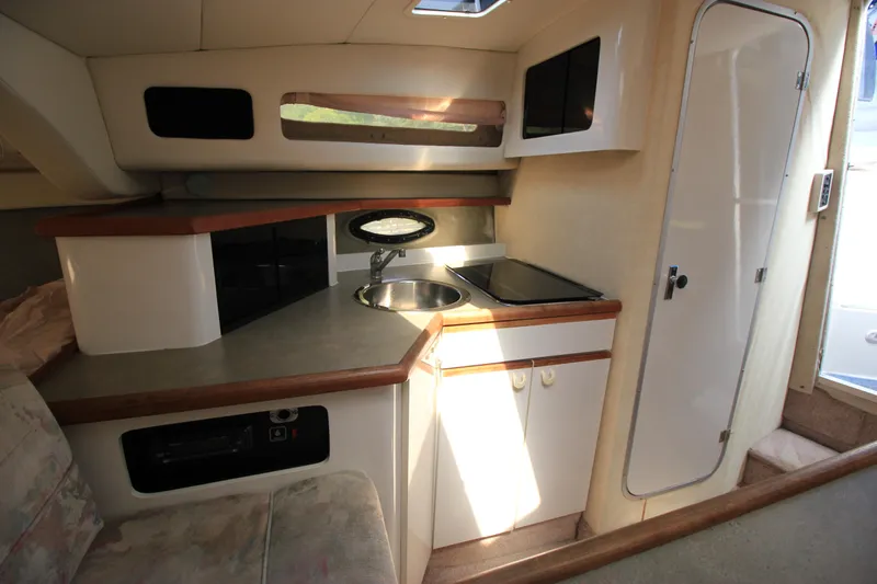 Slide: The Image of 1994 Bayliner 3055 Sunbridge interior kitchen with sink, stove, and storage cabinets. - 17