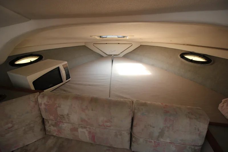 Slide: The Image of 1994 Bayliner 3055 Sunbridge cabin interior with bed, microwave, and sofa. - 18