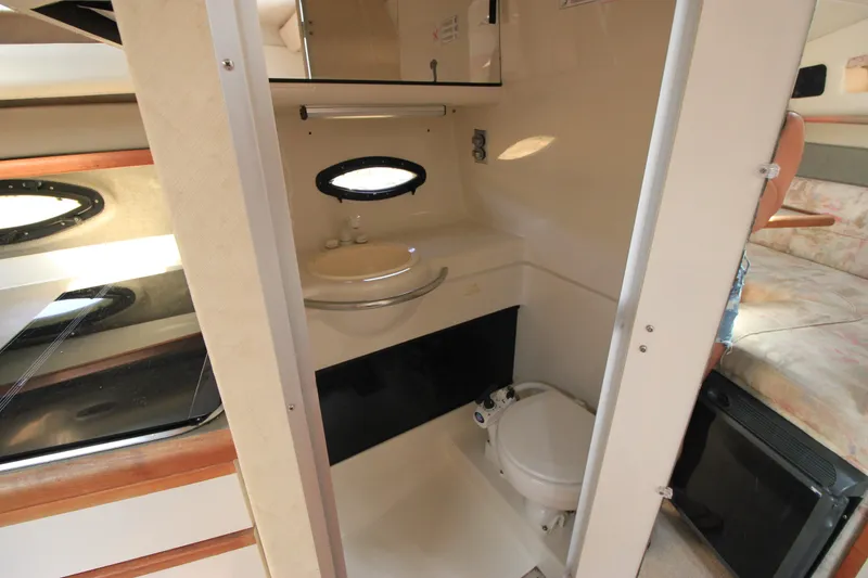 Slide: The Image of 1994 Bayliner 3055 Sunbridge bathroom with sink, toilet, and porthole window. - 20