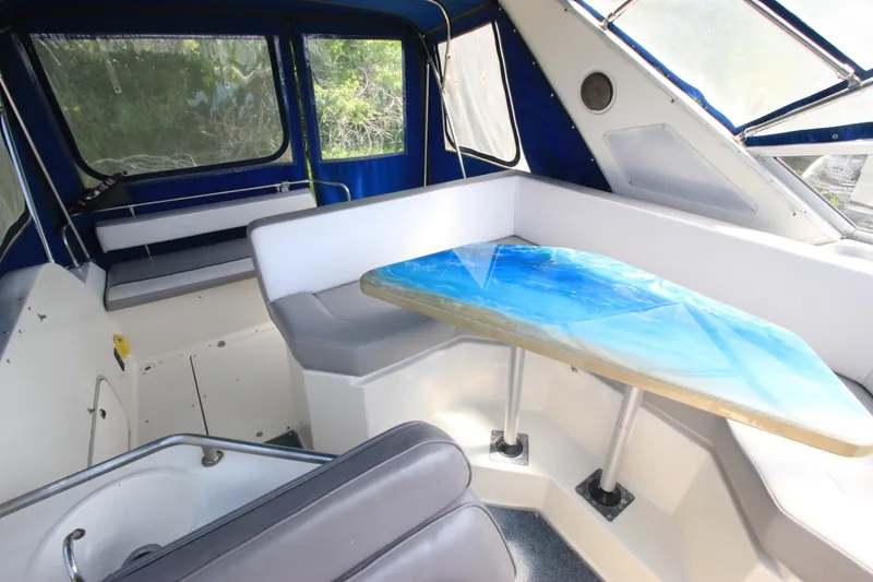 Slide: The Image of 1994 Bayliner 3055 Sunbridge interior with blue table and seating area. - 7