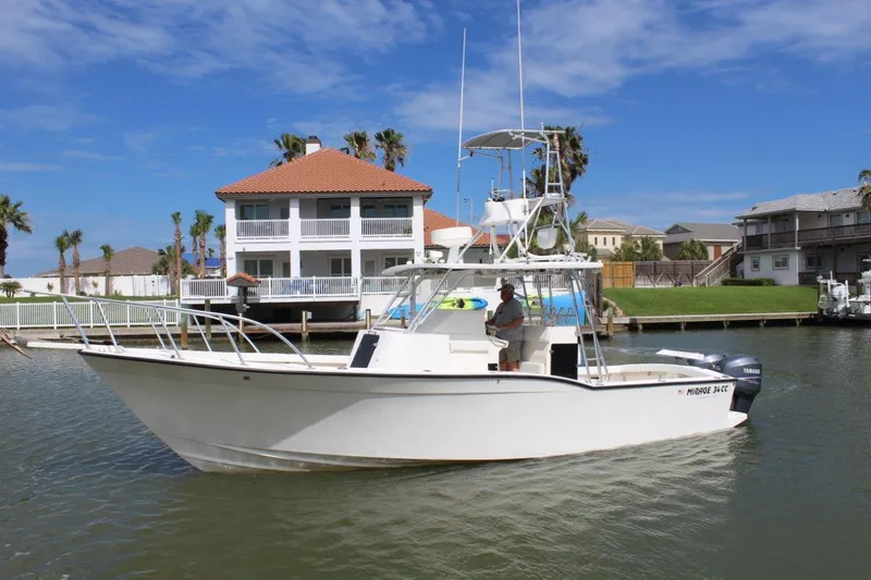 Slide: The Image of 1999 Mirage 34 Walk Around boat cruising in a residential canal. - 1