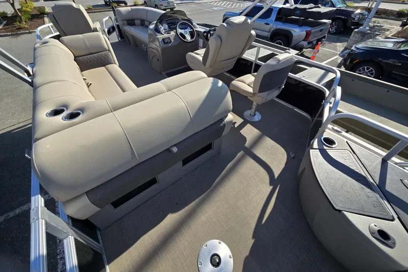 Slide: The Image of 2023 Sun Tracker SportFish 20 DLX pontoon boat interior with beige seating and steering console. - 12