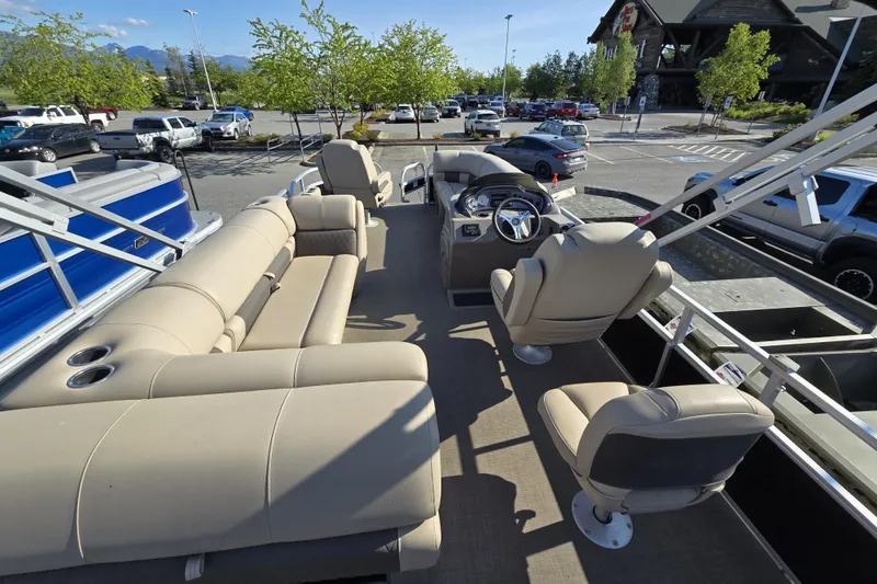 Slide: The Image of 2023 Sun Tracker SportFish 20 DLX pontoon boat with beige seating in a parking lot. - 11