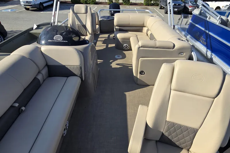 Slide: The Image of 2023 Sun Tracker SportFish 20 DLX pontoon boat interior with beige seating and helm. - 9