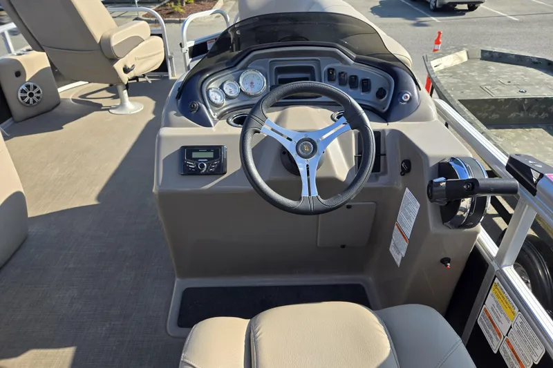 Slide: The Image of 2023 Sun Tracker SportFish 20 DLX boat dashboard with steering wheel and controls. - 13
