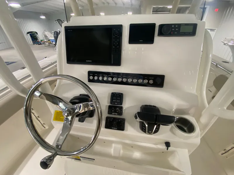 Slide: The Image of 2024 Key West 244 CC boat dashboard with steering wheel and electronic controls. - 10